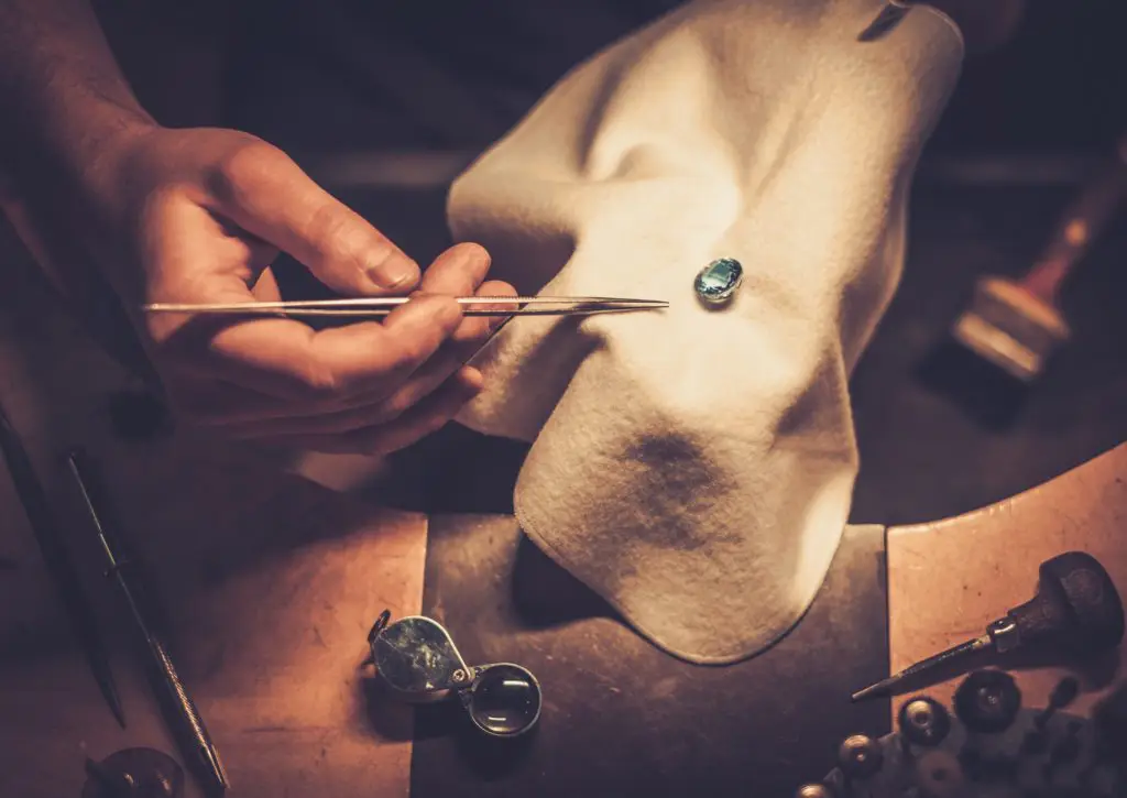 Gemstone Care: A jeweler inspects a gemstone while crafting a unique piece of jewelry.